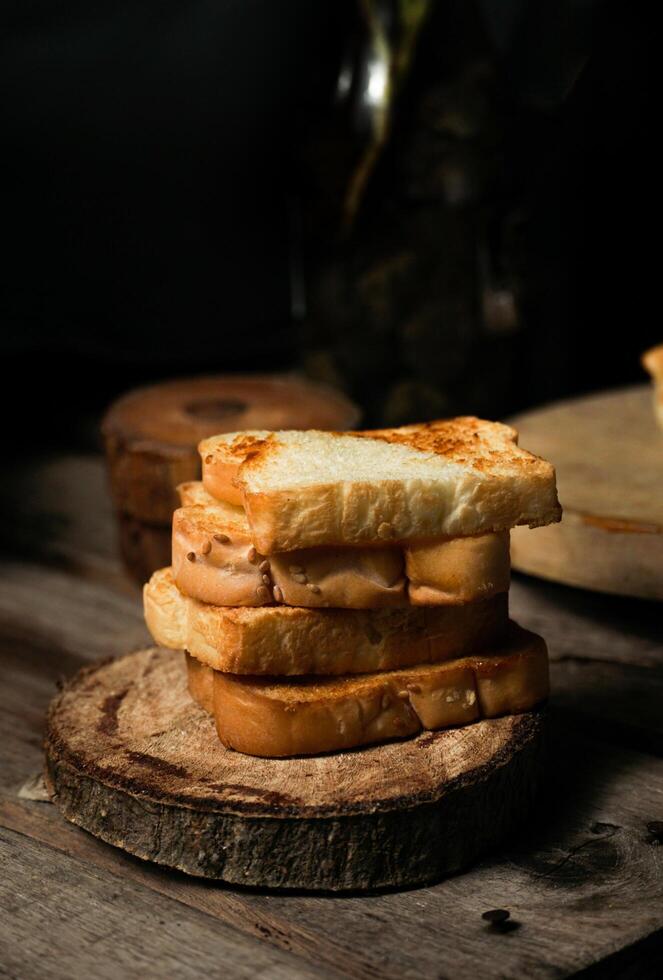 a pile of toasted white bread on the wooden paddle. a shot of the western breakfast suitable for advertisement or presentation. photo