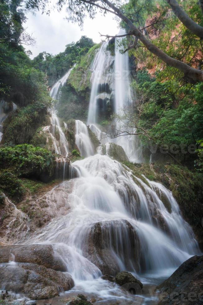 Erawan waterfall 7th floor with water flowing in tropical rainforest at national park photo