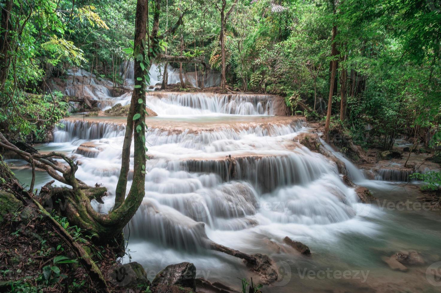 Beautiful Erawan waterfall flowing in tropical rainforest at national park photo