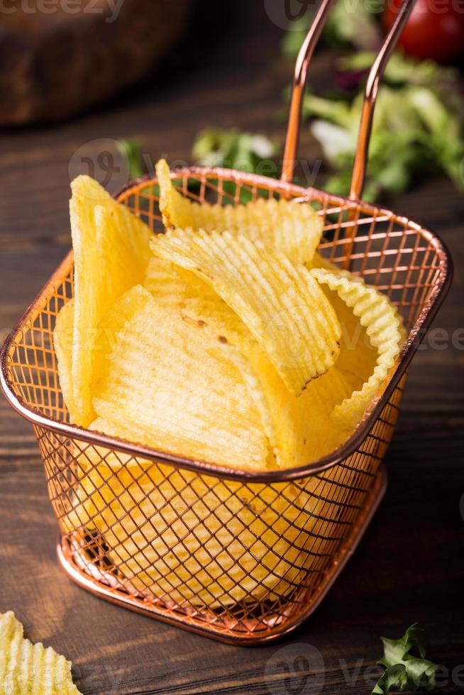 Patatas fritas crujientes en canasta de cobre foto