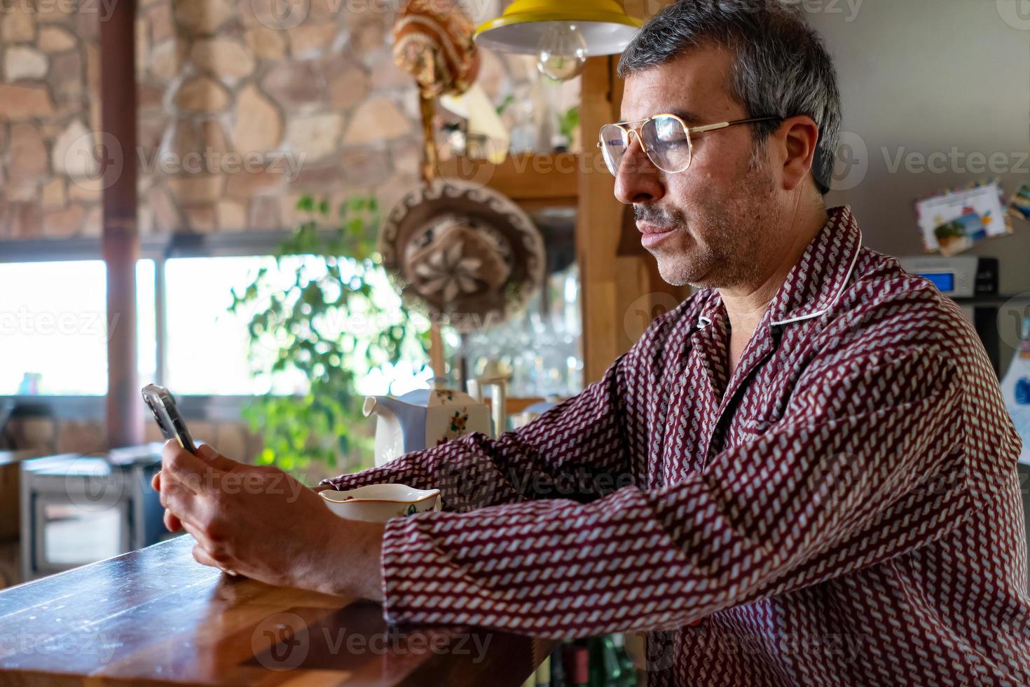 Man at home looking his cellphone photo