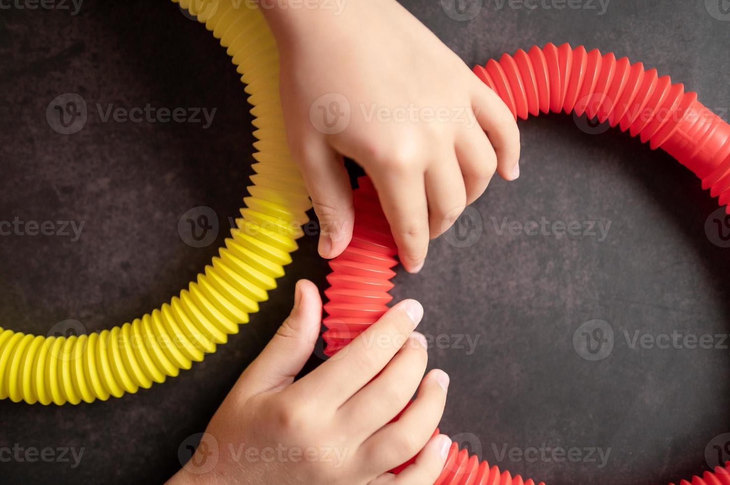 pop tube poptube kid children toy antistress hands holding playing photo