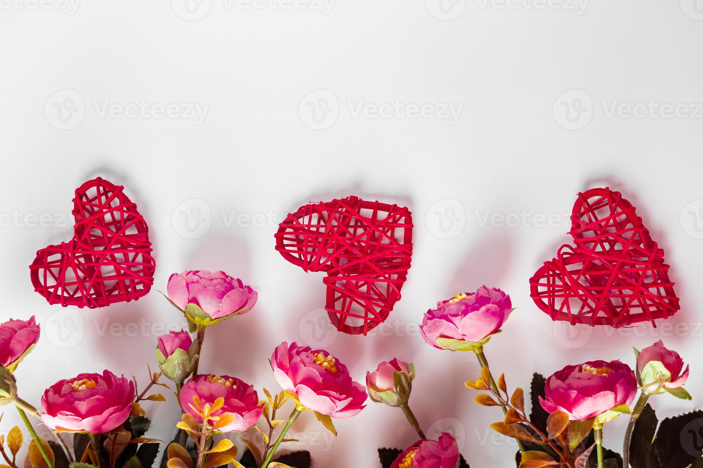 flores y corazones rojos sobre un fondo blanco para el día de san valentín foto