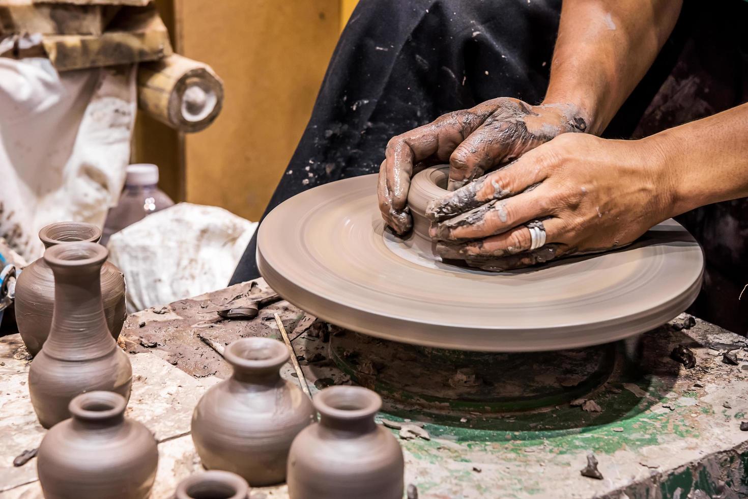 A potter is sculpting a pot. photo