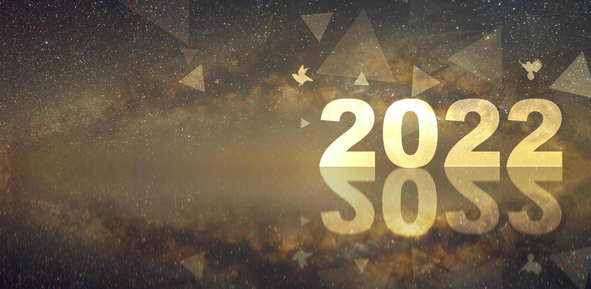 diseño horizontal panorámica de feliz año nuevo 2022 con fuegos artificiales y fondo de la vía láctea. foto