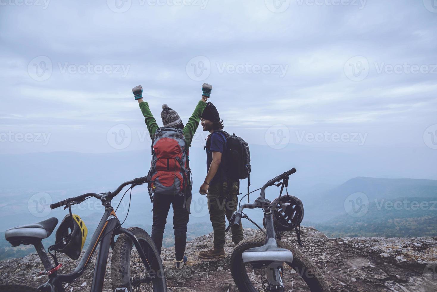 amantes asiáticos mujeres y hombres viajan por la naturaleza. viajar relajarse andar en bicicleta desierto en la naturaleza. de pie sobre un acantilado rocoso. tailandia foto