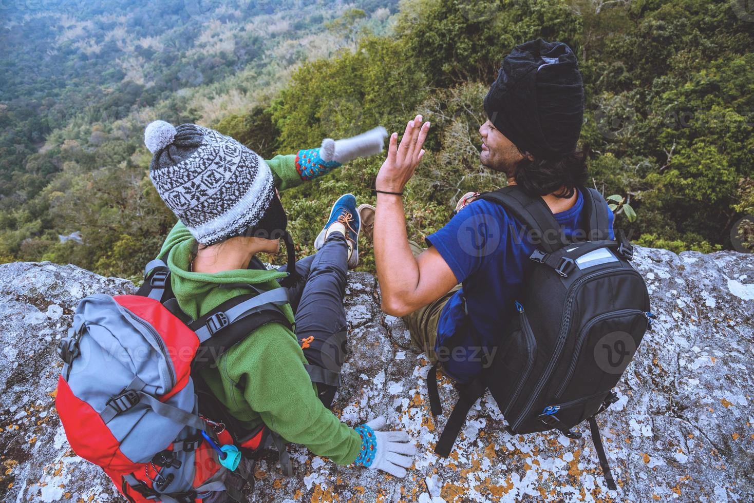 amantes asiáticos mujeres y hombres viajan por la naturaleza. viajar relajarse. sentarse y mirar la vista de la montaña. en un acantilado en la montaña. tailandia foto