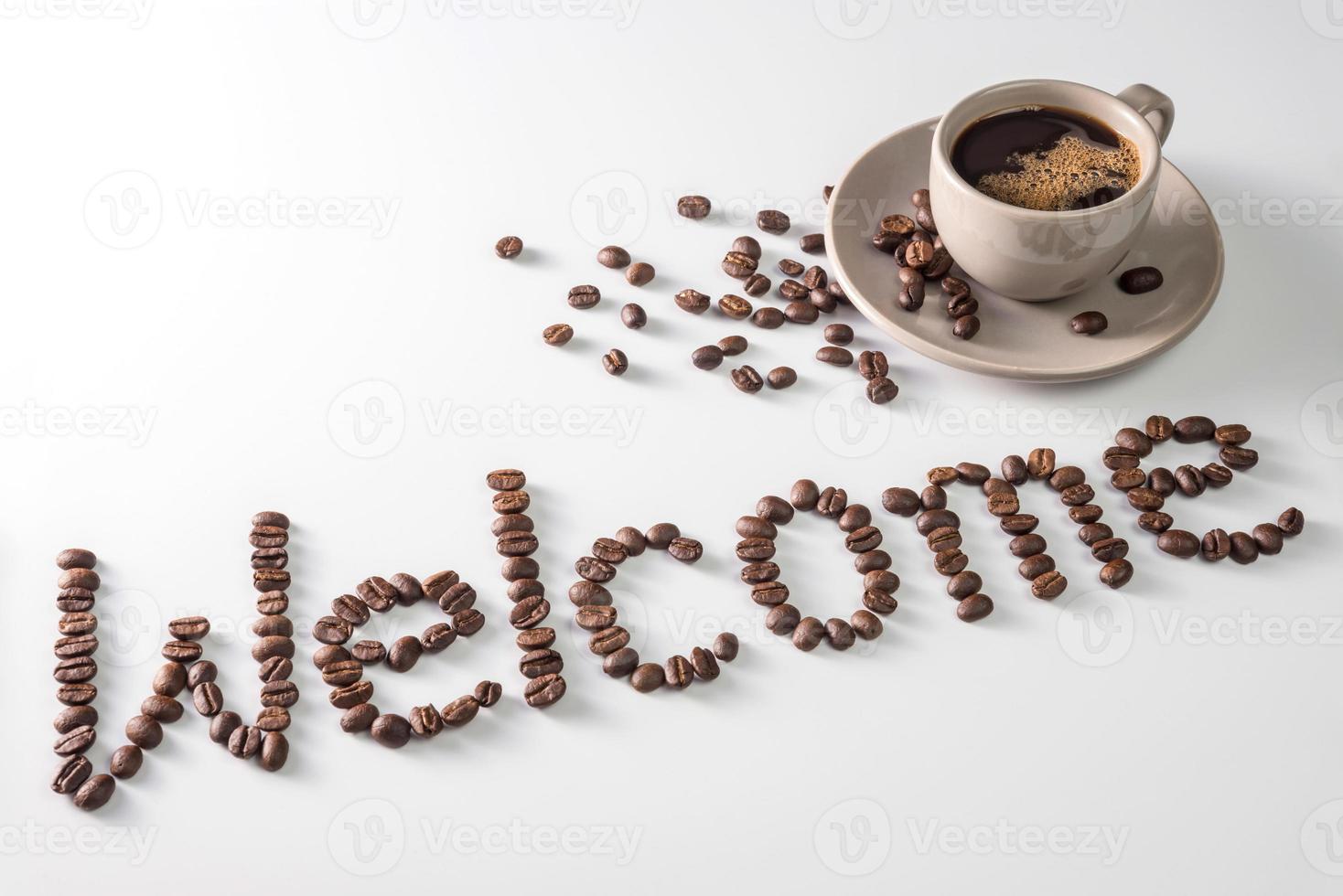 taza de café y texto de granos de café, aislado en blanco. envía un mensaje de texto a la palabra bienvenida hecha de granos de café. fuente foto