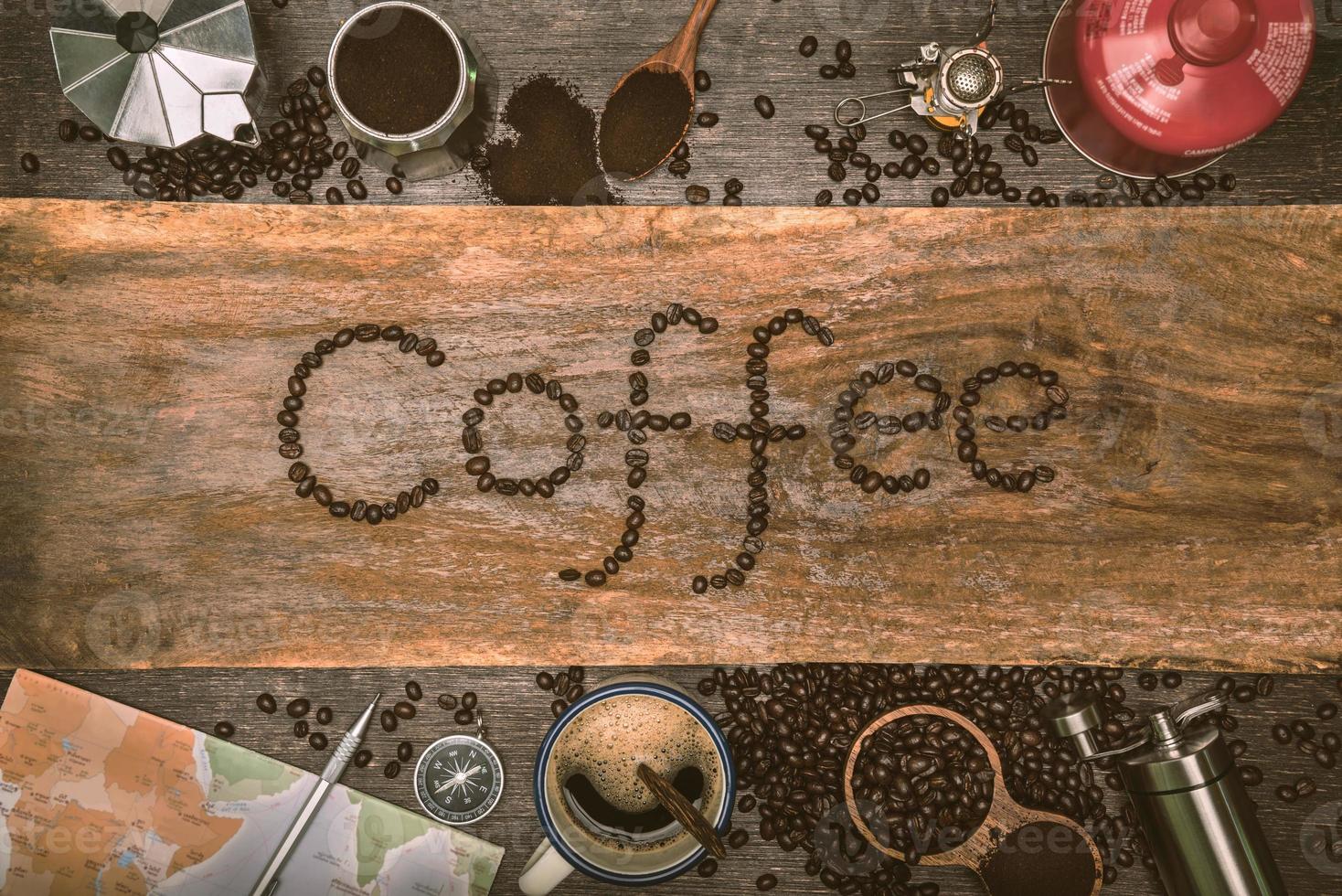 equipment material about coffee beans. Top view with copy space for your text. Coffee message write on a wooden table. Concept travel with map. photo