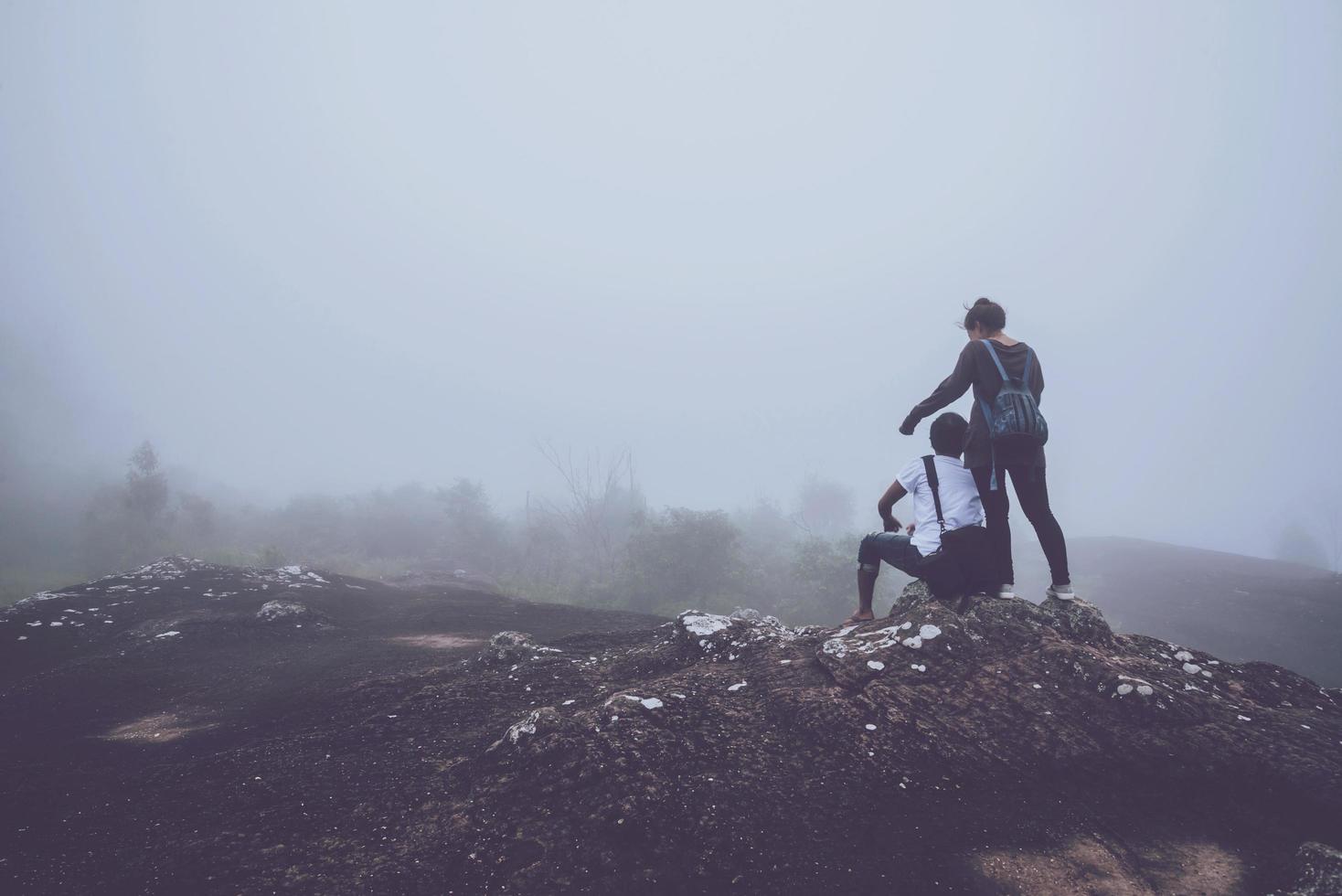 Lover women and men asians travel relax in the holiday. On a rocky mountain. Wild nature wood on the mountain. photo