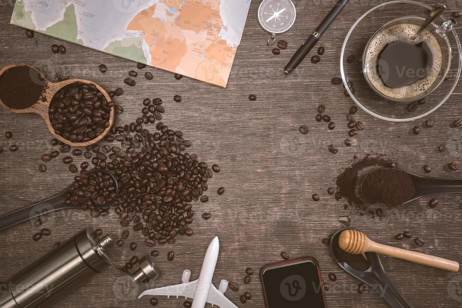 Granos de café marrón y una taza de café caliente colocados sobre una mesa de madera. concepto de viaje con mapa. tiempo para relajarse con una taza de buen café. espacio de copia de vista superior para su texto. foto