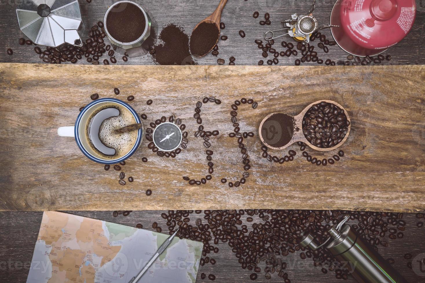 equipment material about coffee beans. Top view with copy space for your text. Coffee message write on a wooden table. Concept travel with map. photo