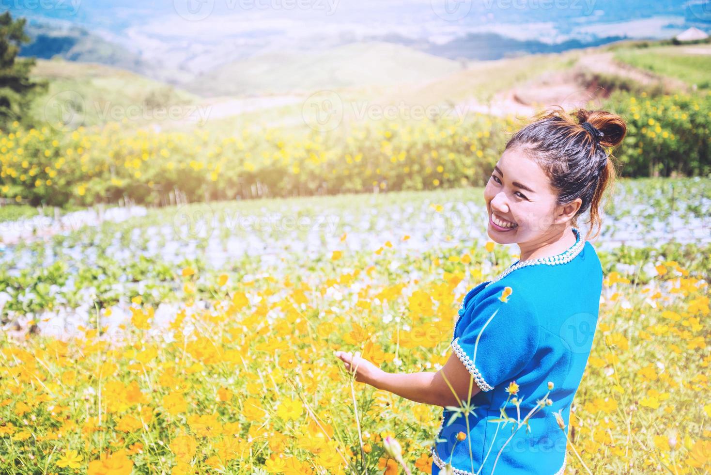 las mujeres asiáticas viajan dormir relajarse. mujeres de la tribu de las colinas en el campo de flores cosmos sulphureus. tailandia foto