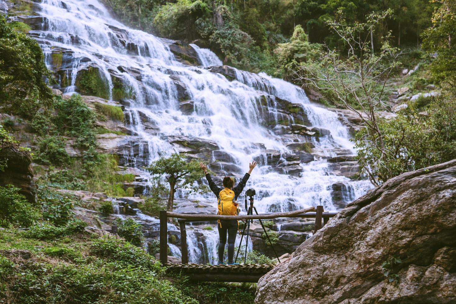 Asian woman travel relax to photograph the waterfalls beautiful. In the winter. at the waterfall mae ya chiangmai in thailand. travel nature. summer photo