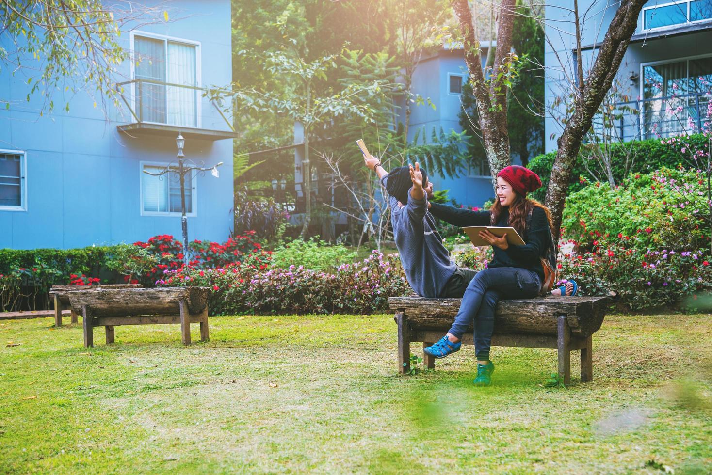 pareja asiática sonrió y estaba feliz con el libro leído. entre los hermosos jardines de flores, San Valentín foto