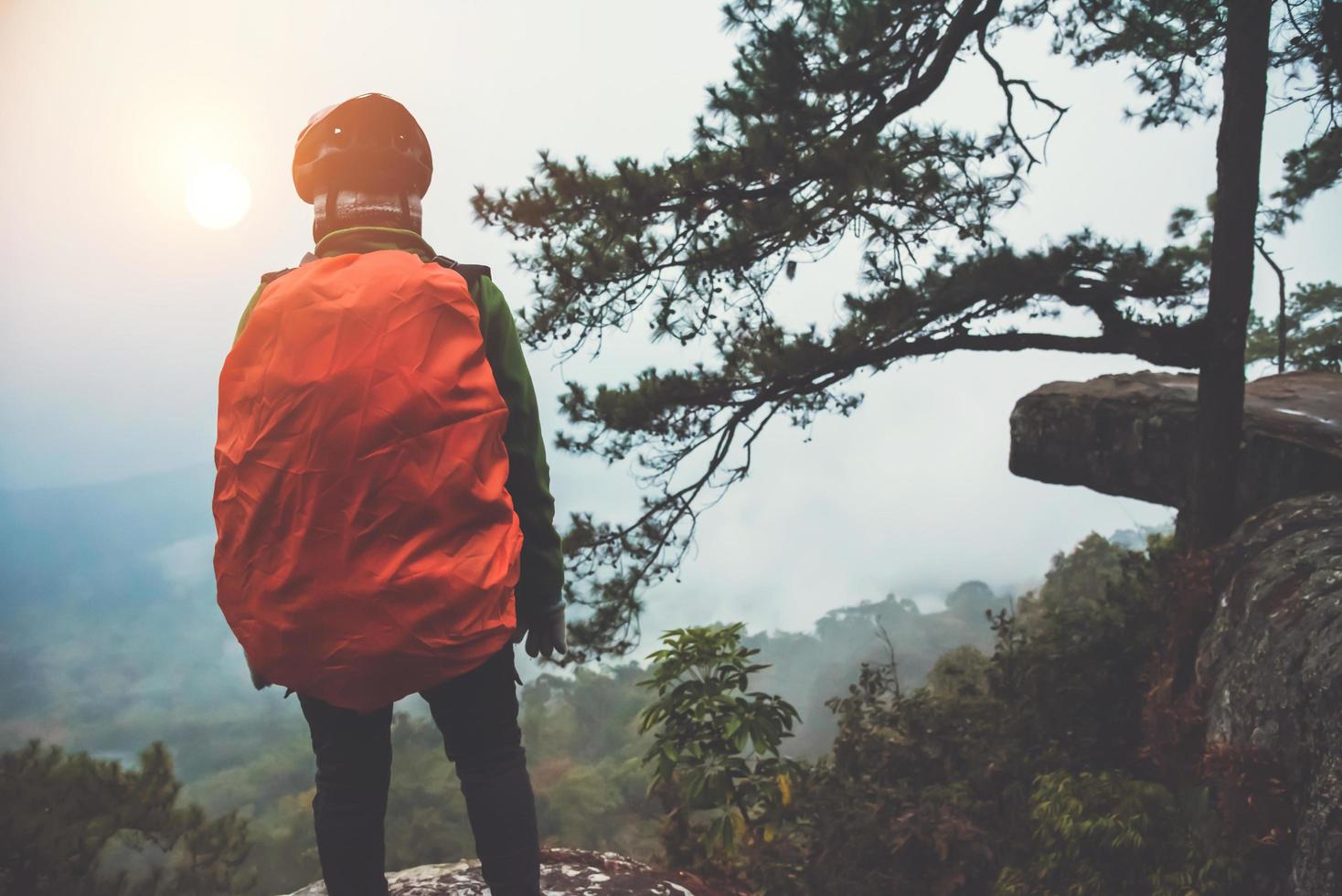 Asian women travel nature. Travel relax. Stand up landscapes on the cliff.  At sunrise which has fog guard. Thailand photo