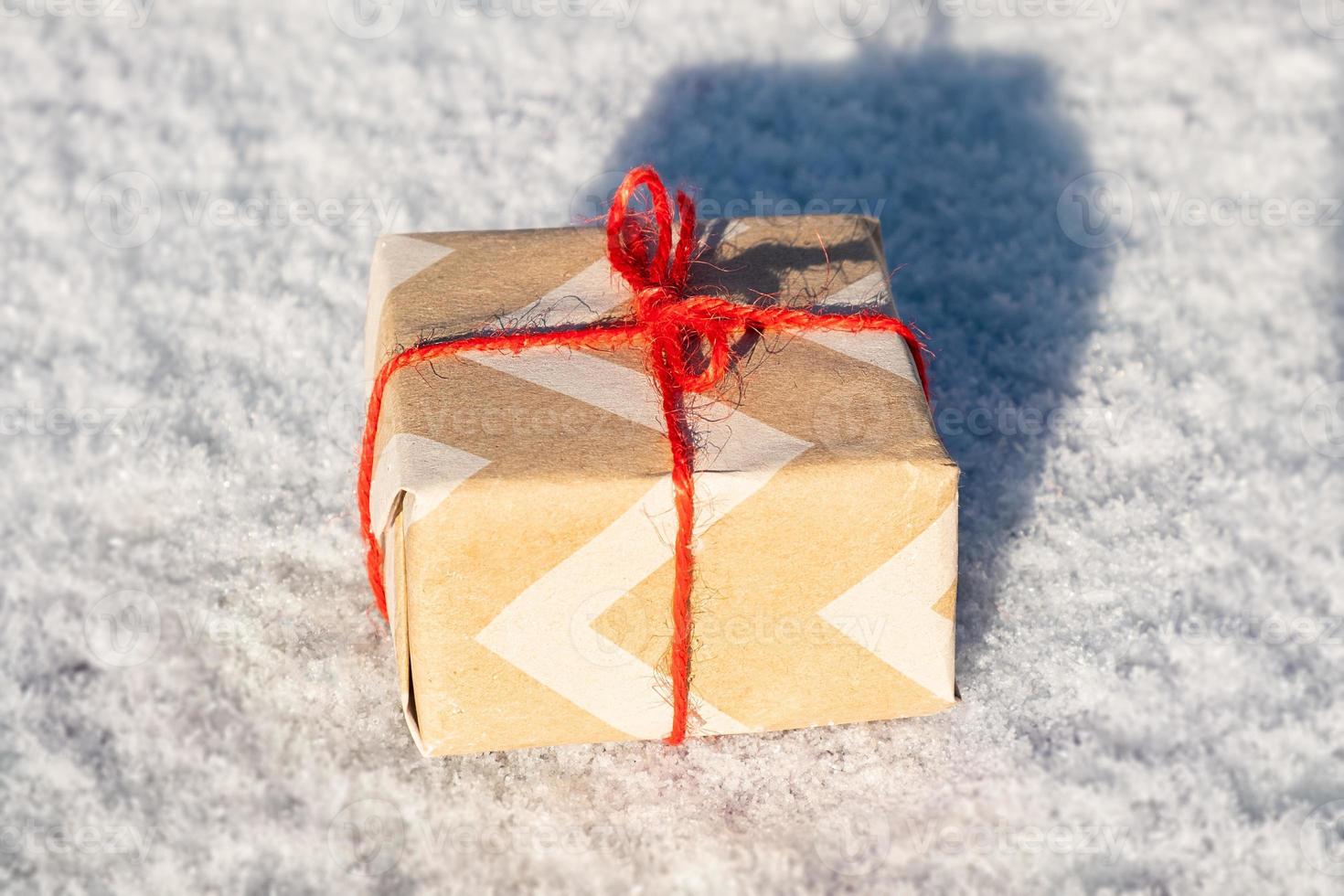 Caja de felicitación de año nuevo con regalo de cerca, regalo de Navidad en la nieve. foto