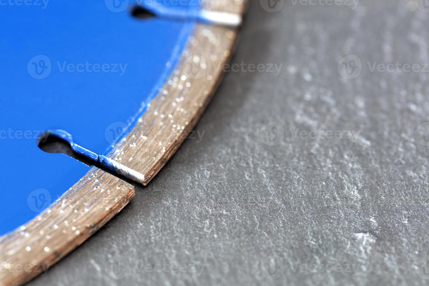 Segment of a diamond cutting disc on a background of gray concrete. photo