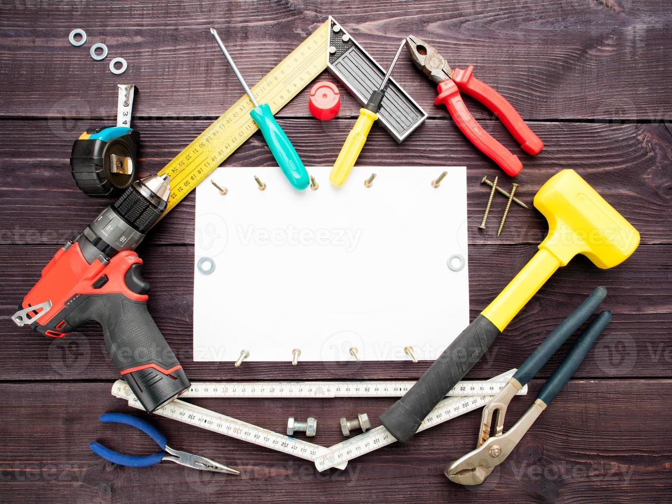The tool building on the wooden background around the white sheet of paper photo
