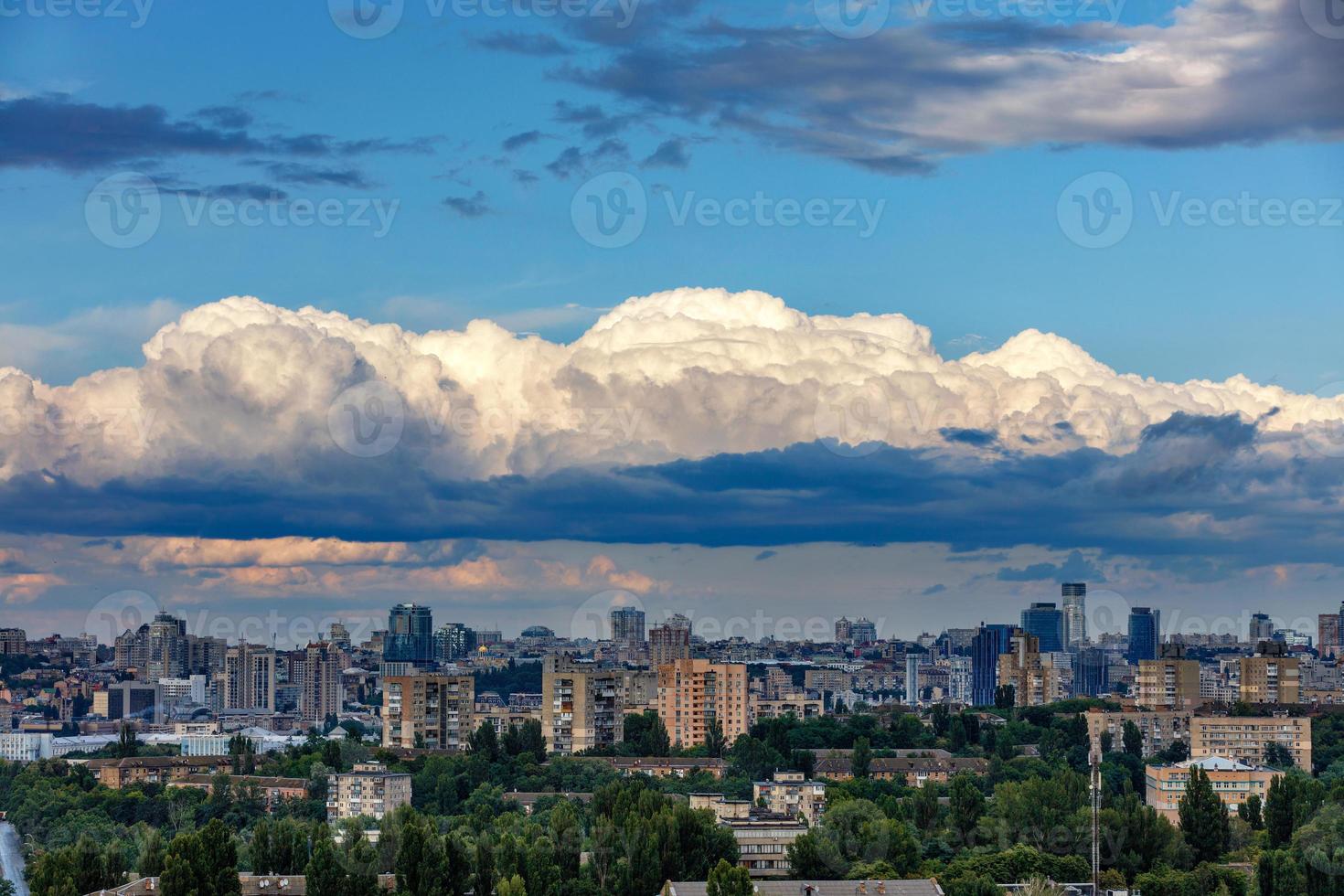 A dense cloud hung at dawn over the sleeping city, the sun's rays illuminate the top caps of white clouds. photo