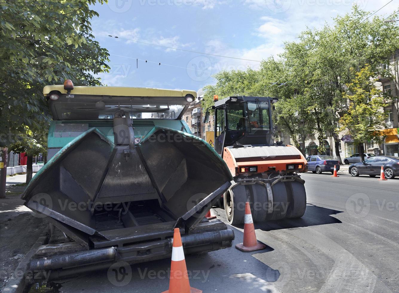 Pavimentadora de asfalto pesado y sello de rodillo vibratorio de carretera listo para reparar carreteras en una ciudad moderna foto