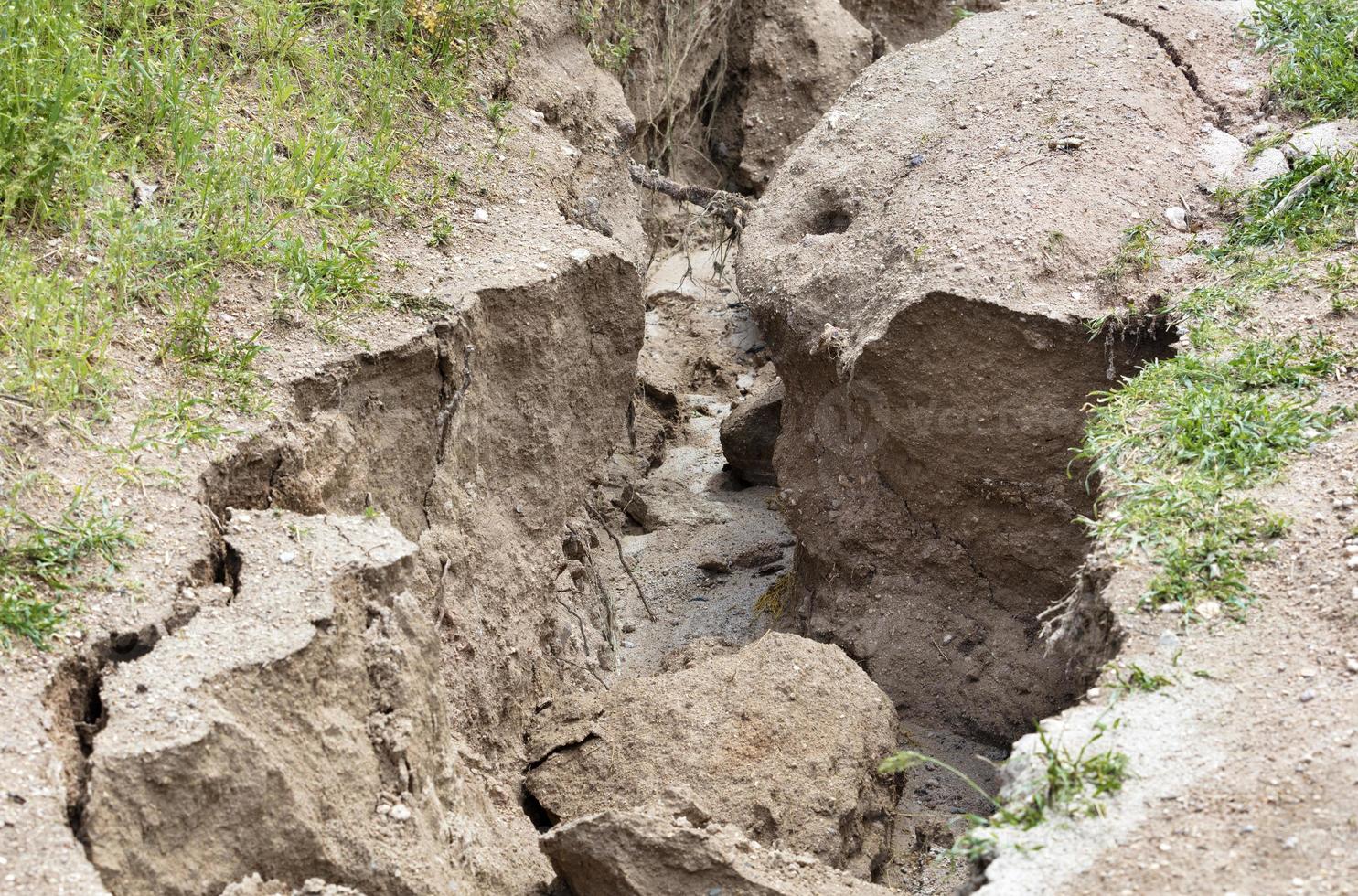 Soil erosion after heavy rain on a mountain path photo