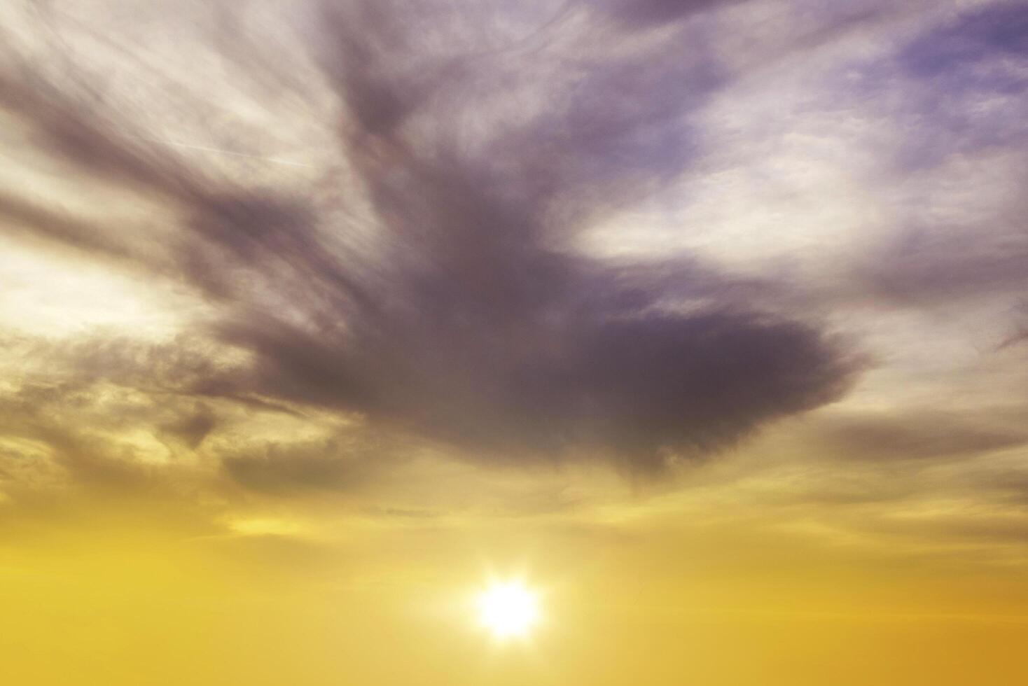 Atardecer y amanecer amarillo brillante hermoso sobre nubes grises con sol naranja brillante en una fresca mañana de primavera. foto