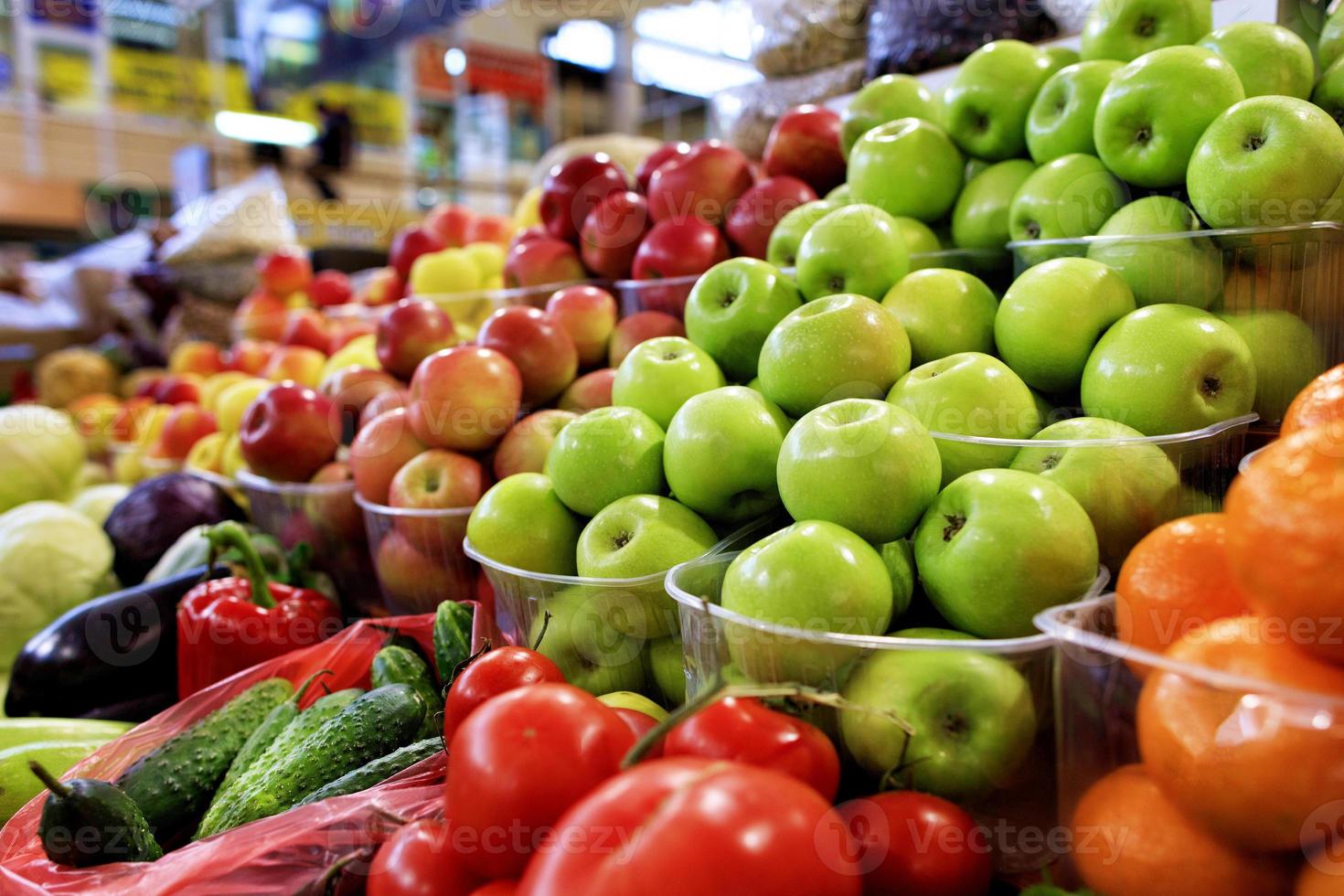 Manzanas verdes, rojas, amarillas, frutas y verduras para la venta en el mercado. foto