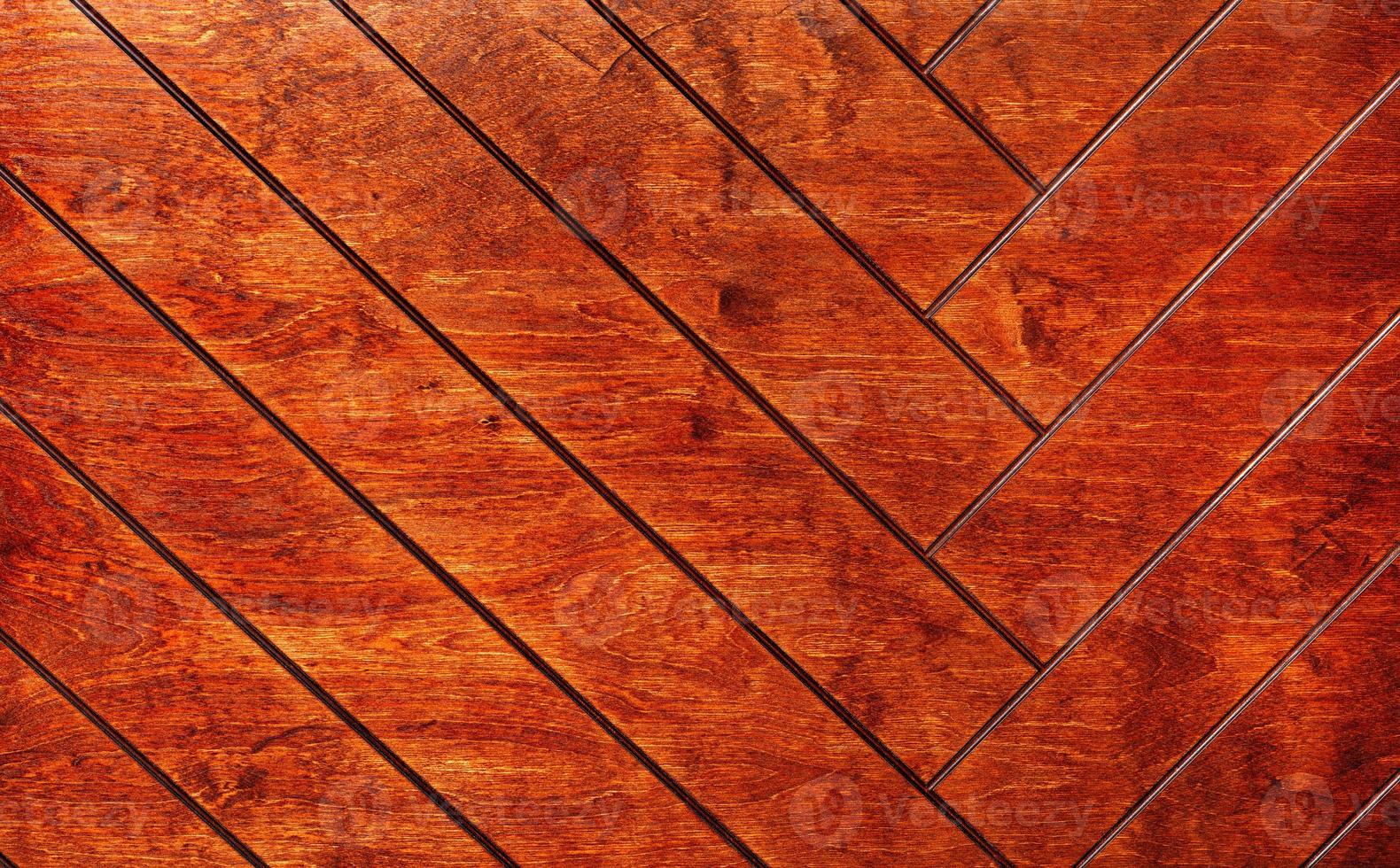 Rectangular boards are painted in orange and neatly laid out with a herringbone pattern. photo