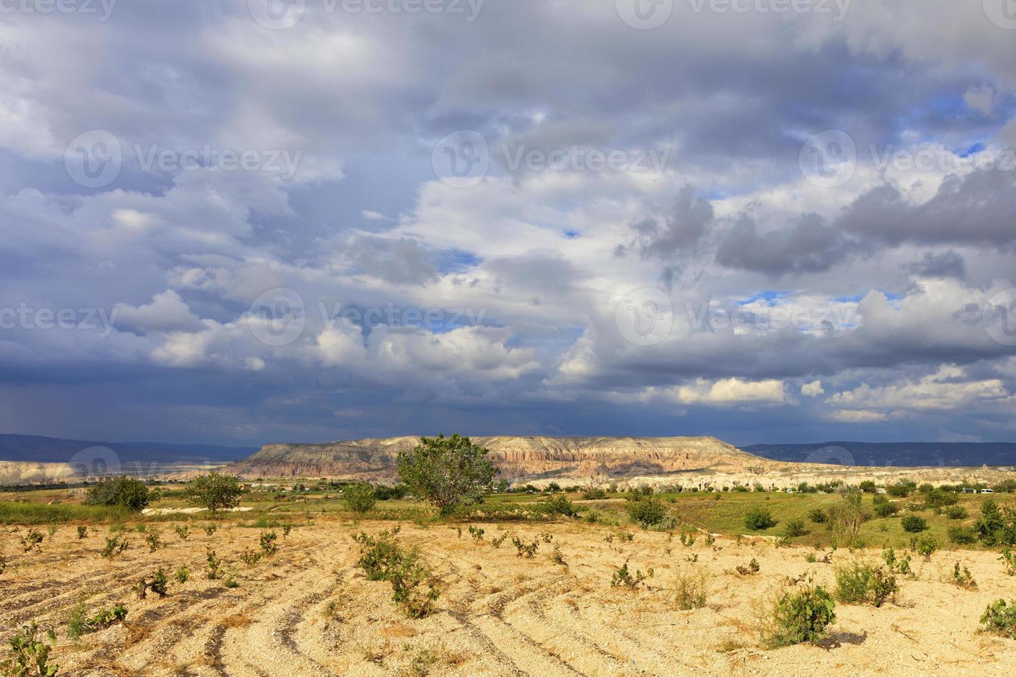 Fascinating landscape of mountain valleys of Cappadocia against the backdrop of thunderstorm clouds of lead-blue sky photo