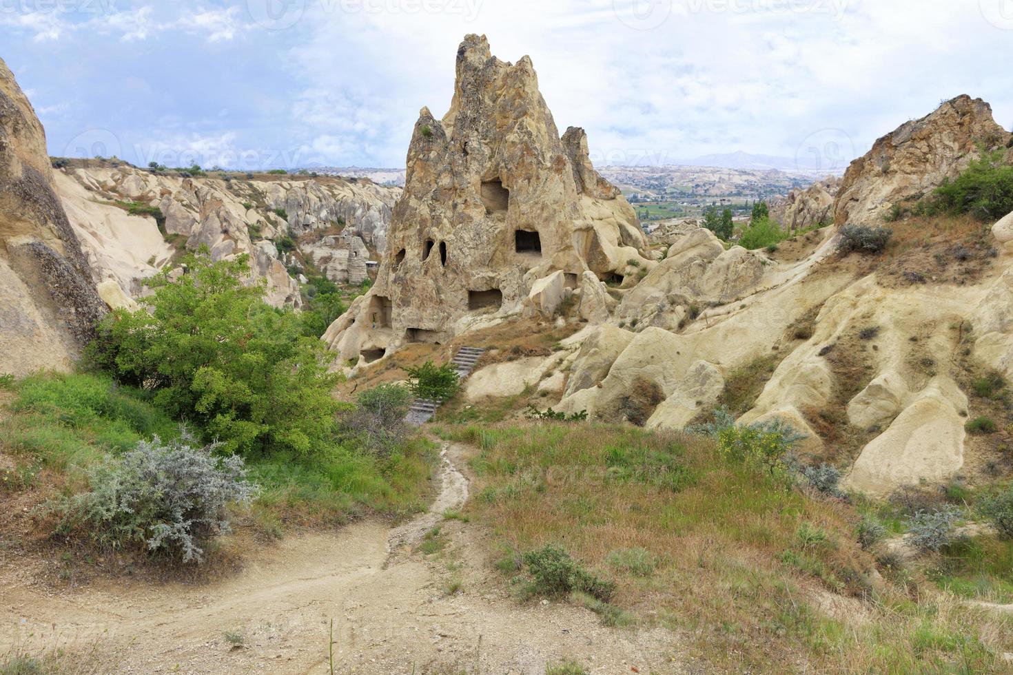 An unearthly landscape and a view of ancient dwellings in ancient cone-shaped caves in the valleys of Cappadocia photo