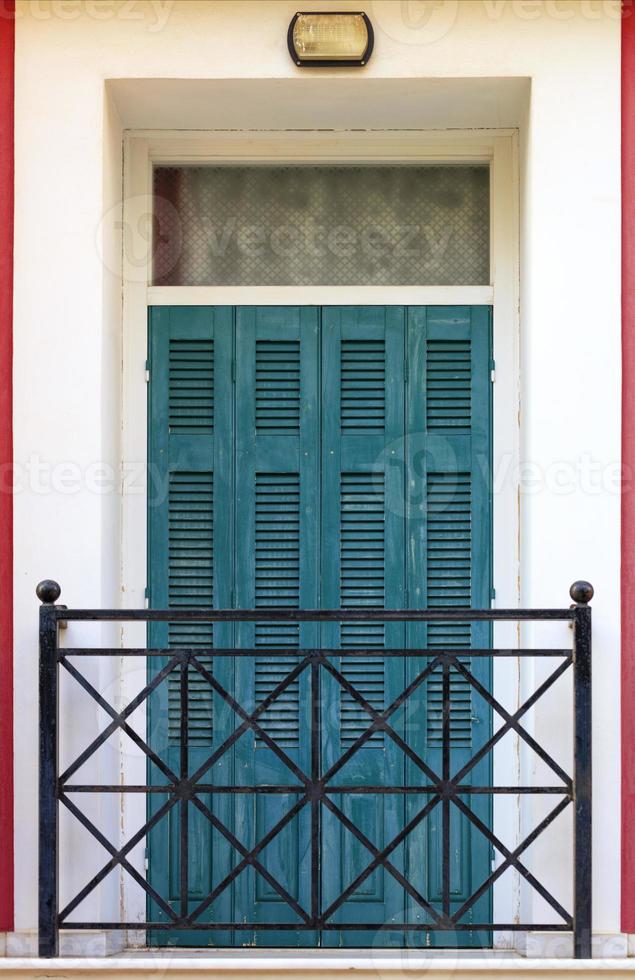 With Puertas De Balcón Antiguas De Madera Verde Con Contraventanas De Madera Y Rejas De Metal En El Balcón De Estilo Griego. foto