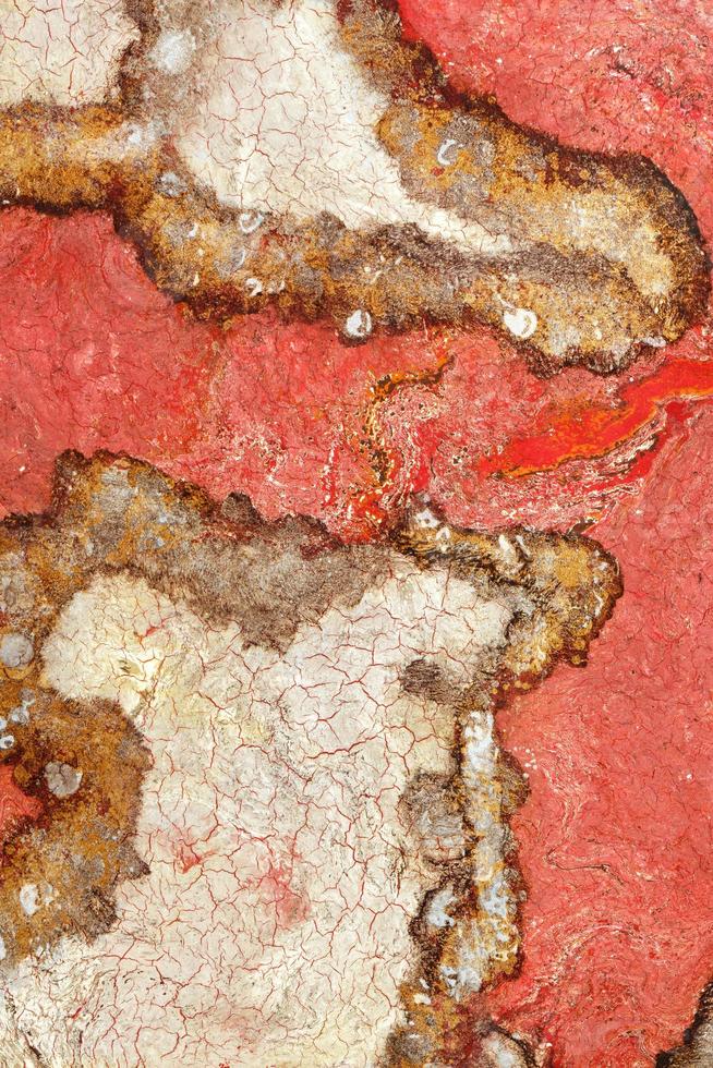 Fiery red surface, texture and background of red granite with cracked beige and brown fractals. photo