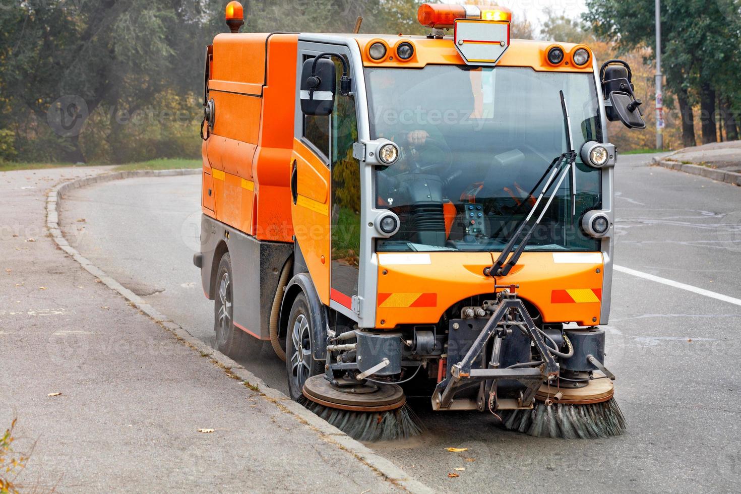 A hydraulically powered road sweeper sweeps the street. photo