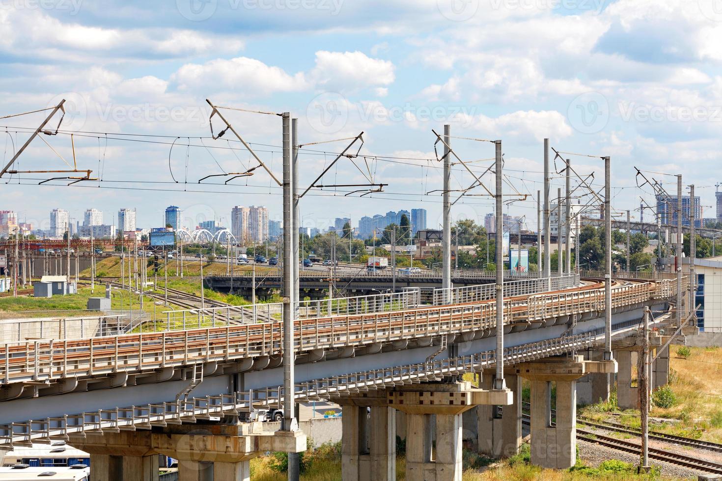 A powerful multi-level railway network with a bend and a flyover against the backdrop of a cityscape. photo