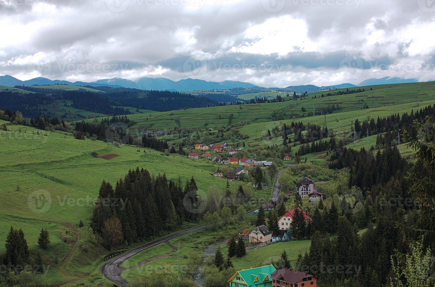 Vista desde la altura de una carretera sinuosa que pasa por la aldea de los Cárpatos. foto