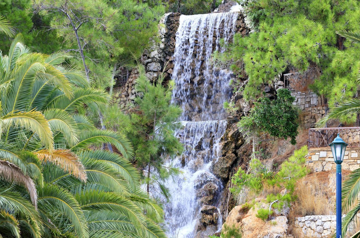 A large waterfall with radon water among boulders at the foot of a mountain in Loutraki, Greece. photo