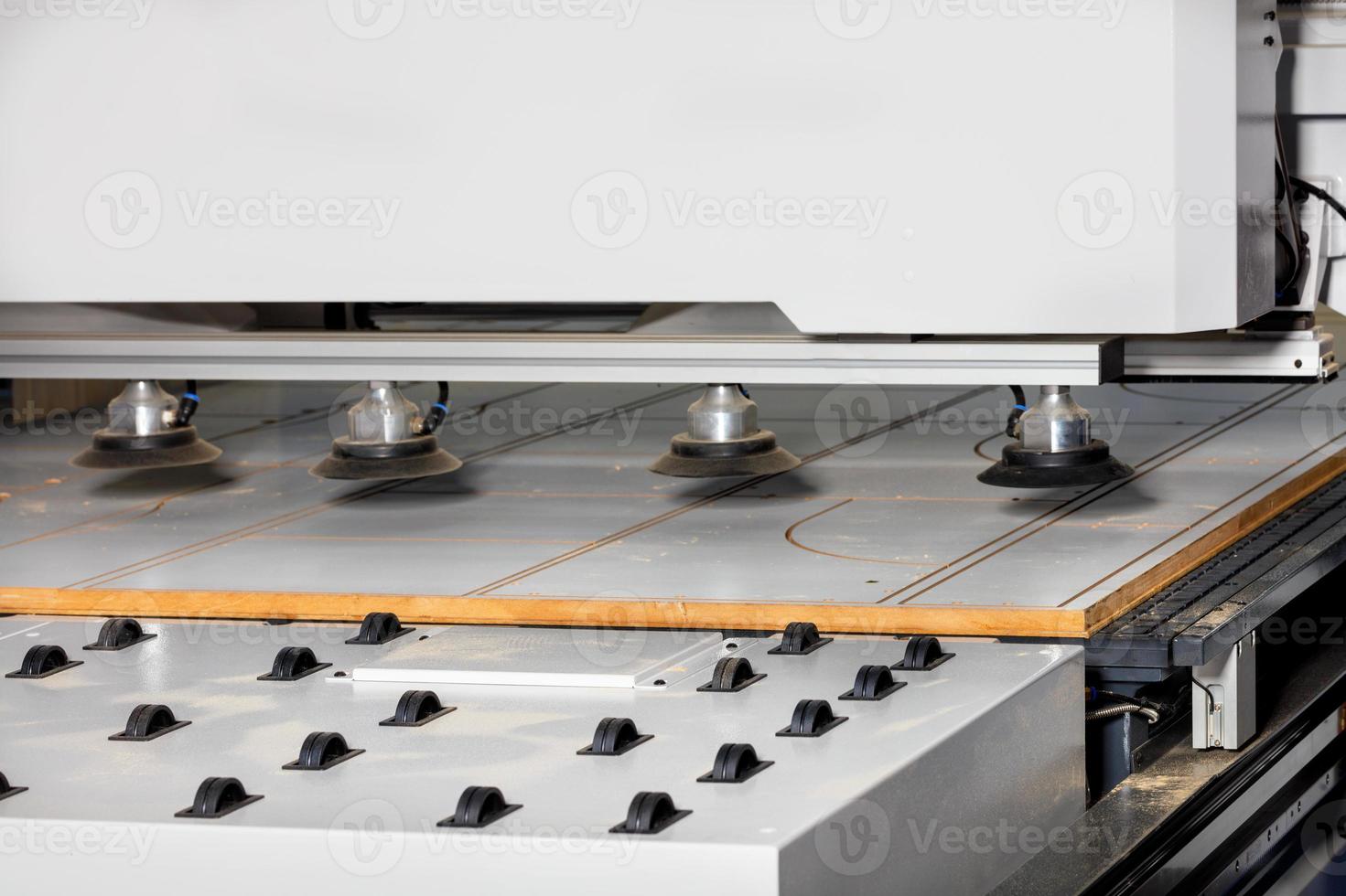 Roller mechanism on a pneumatic chipboard feed line on a modern woodworking milling machine. photo