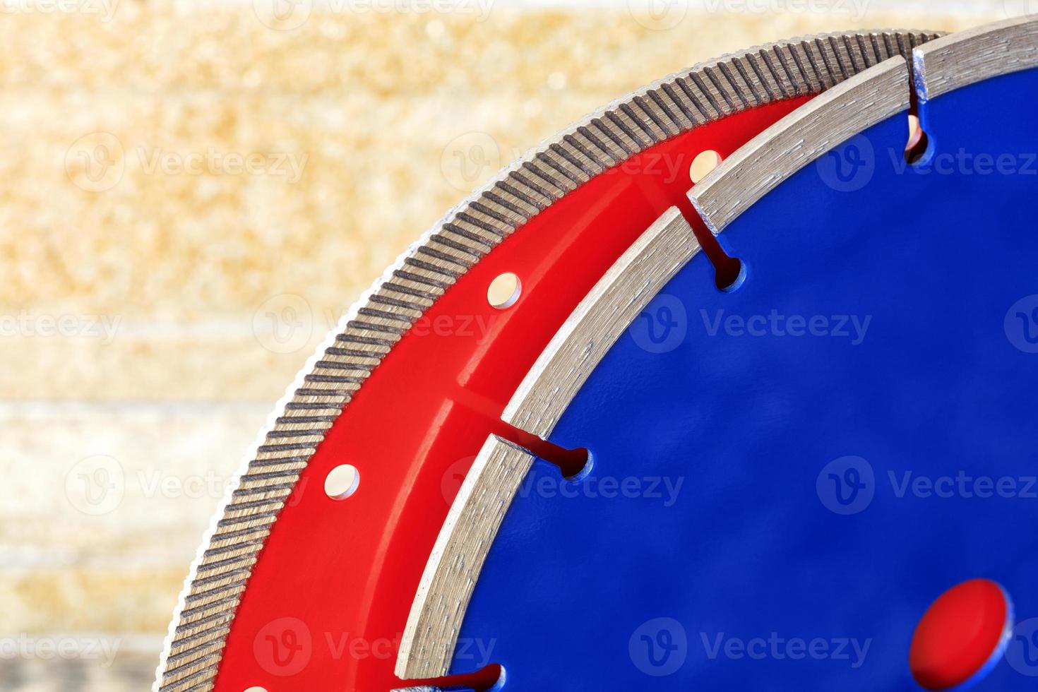 Diamond cutting discs for granite and reinforced concrete on the background of orange-golden sandstone walls. photo