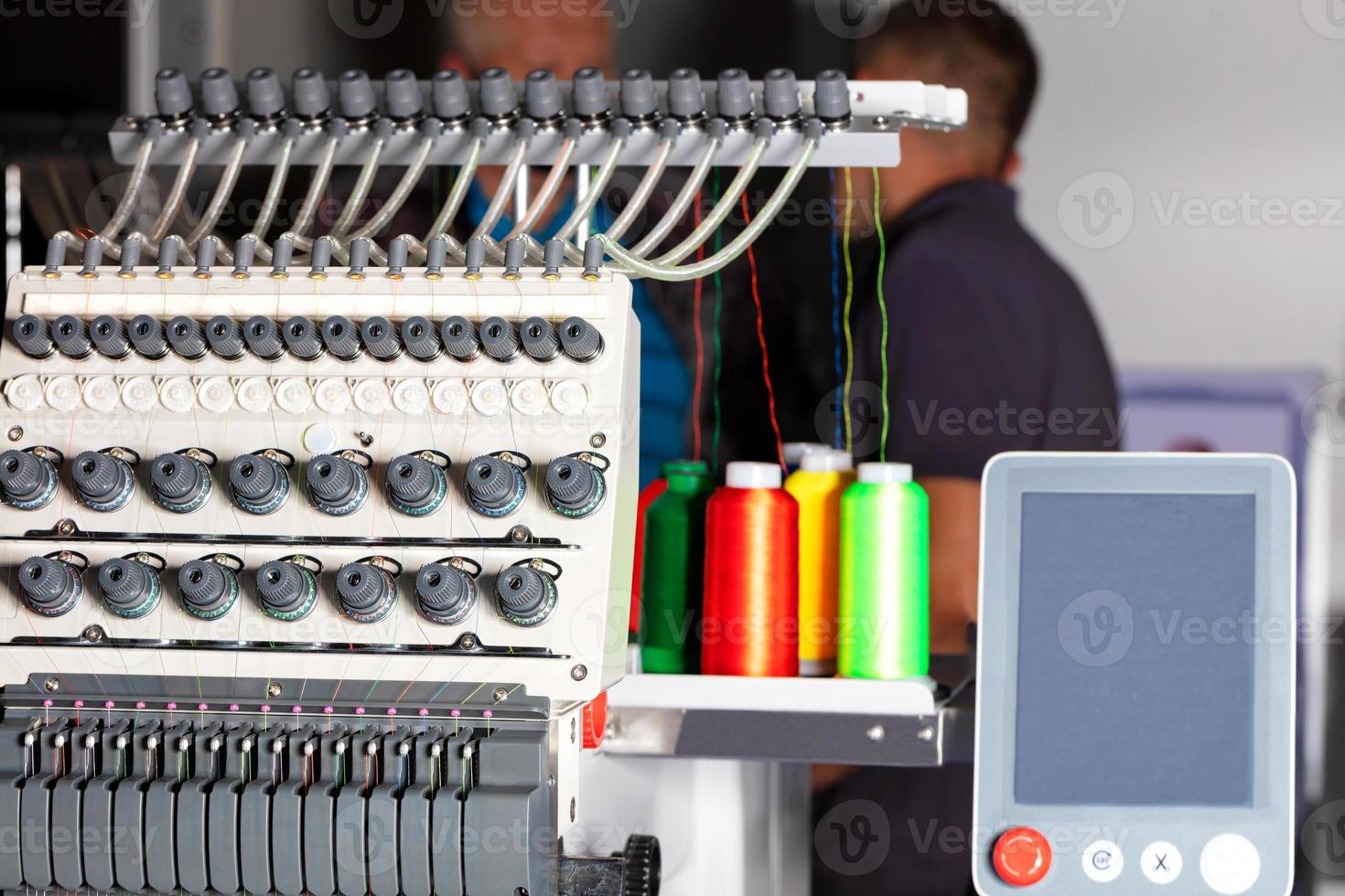 máquina de bordar industrial con hilos multicolores, primer plano. foto