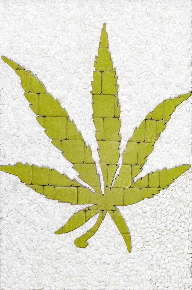 The green cannabis leaf is lined with paving stones. Medical marijuana cultivation concept. photo