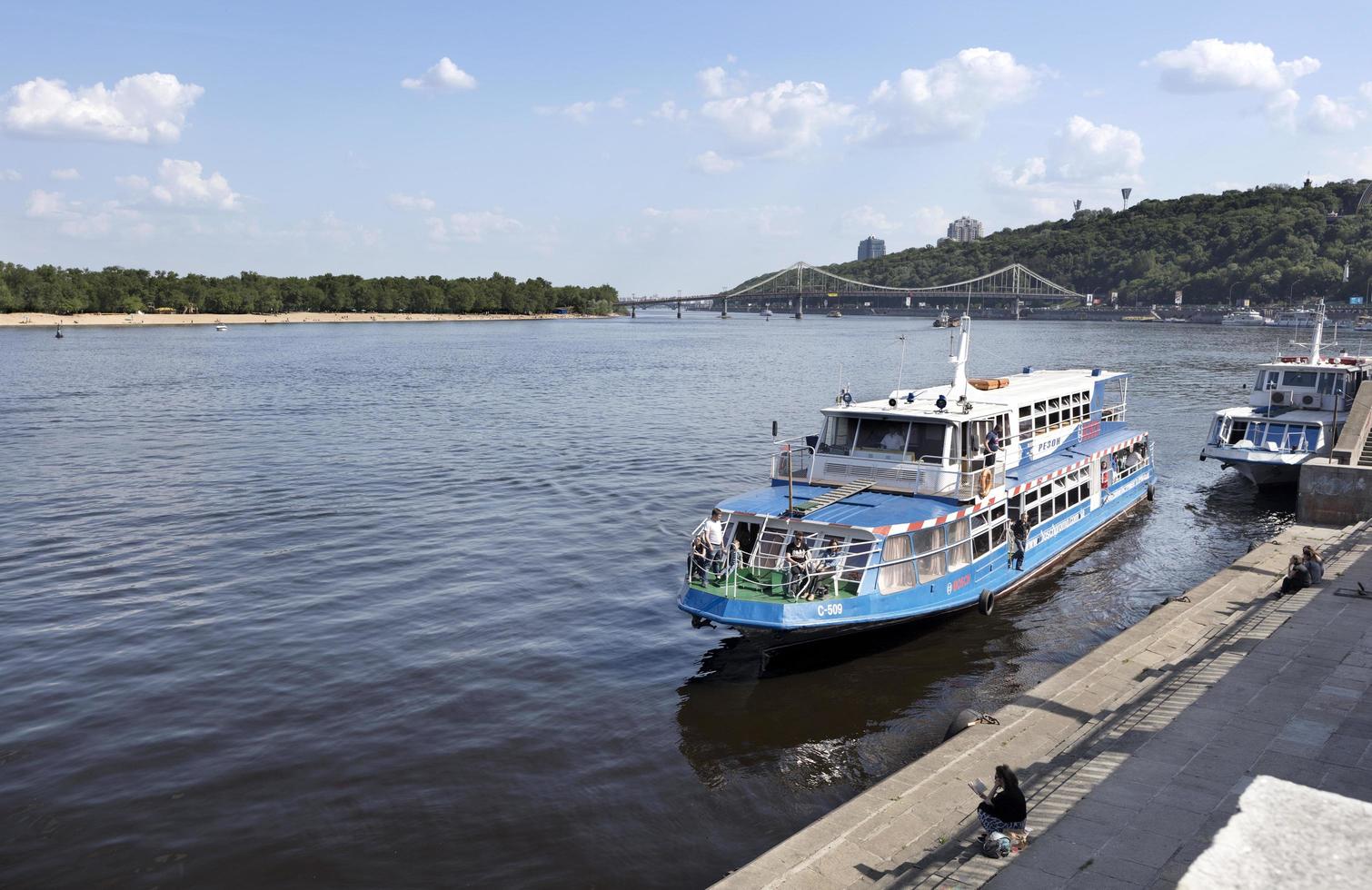 Embarcación de recreo amarrada en el muelle de la ciudad del río Dnieper foto