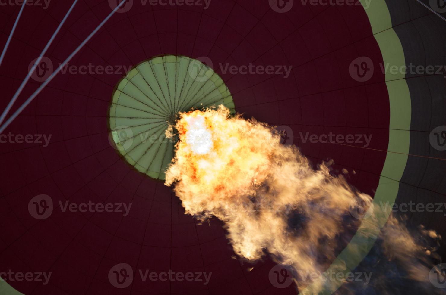 The flame of a gas burner inflates a balloon photo