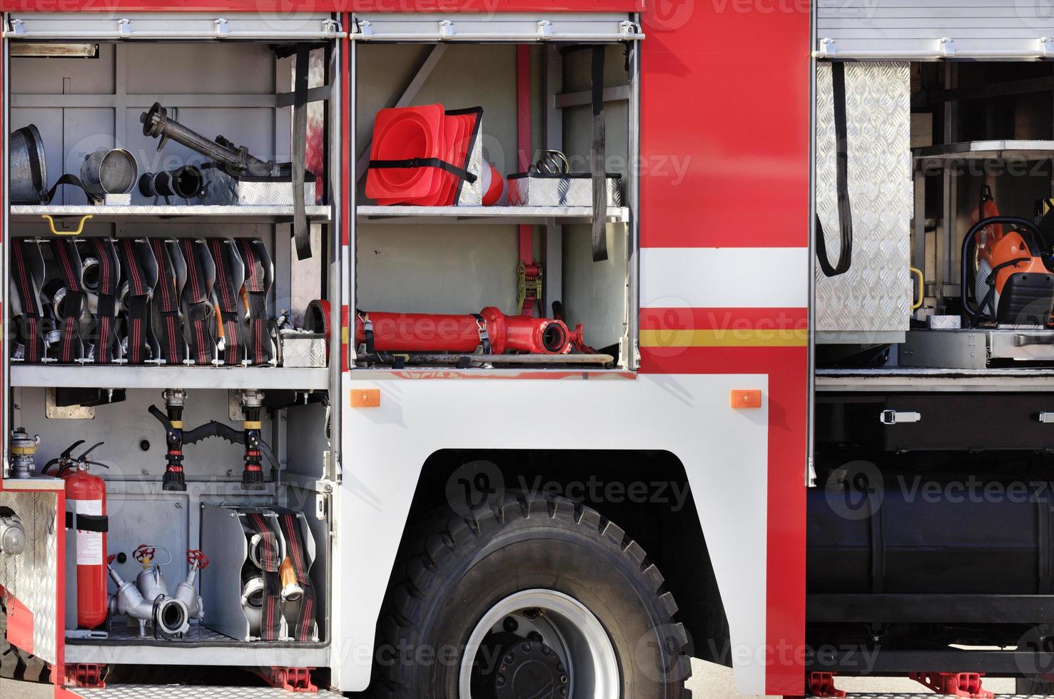 mangueras contra incendios, válvulas y grúas, conos de transporte, extintores manuales se encuentran en el compartimiento de carga de un camión de bomberos equipado. foto