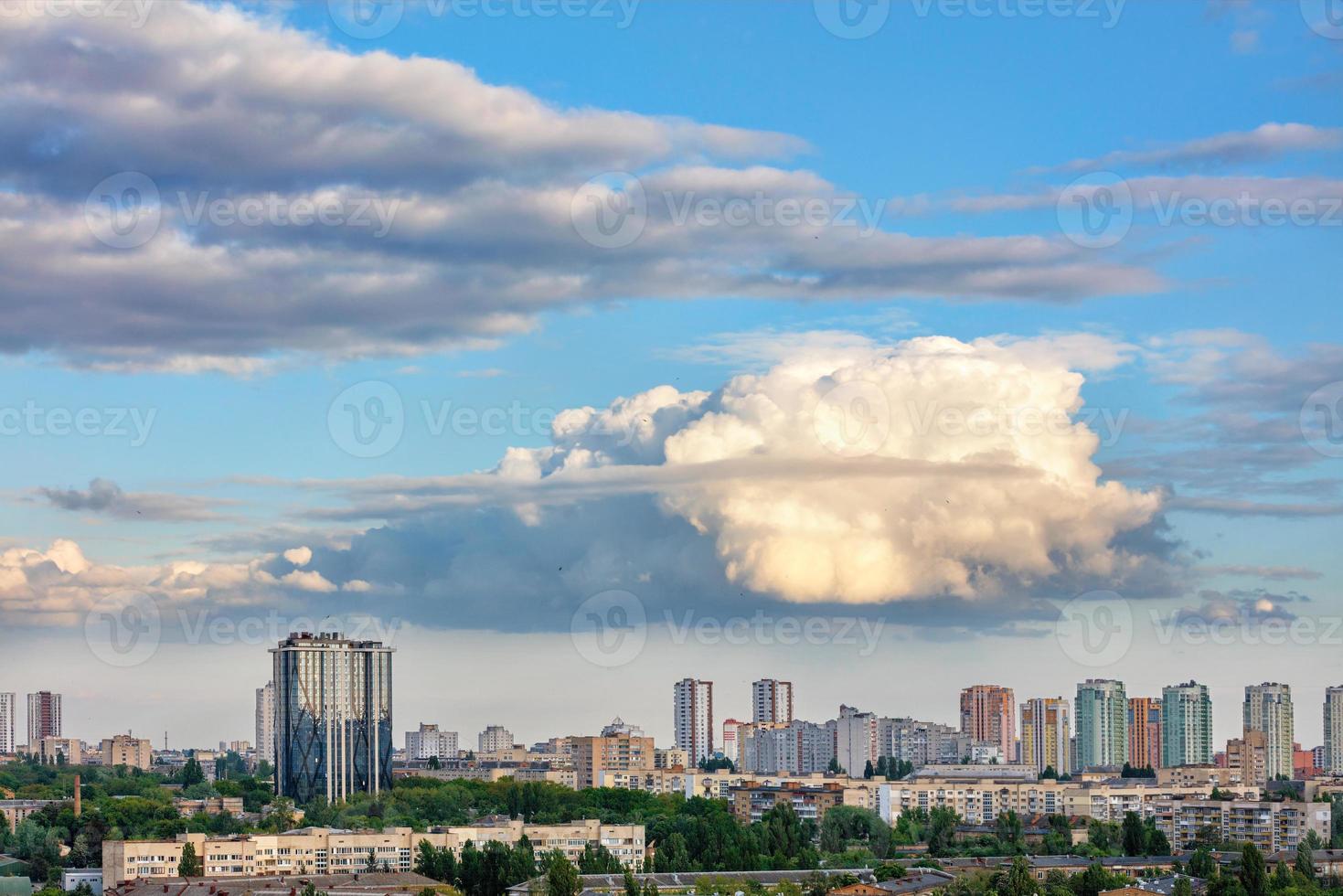 A large curly figured cloud hung over the city. photo