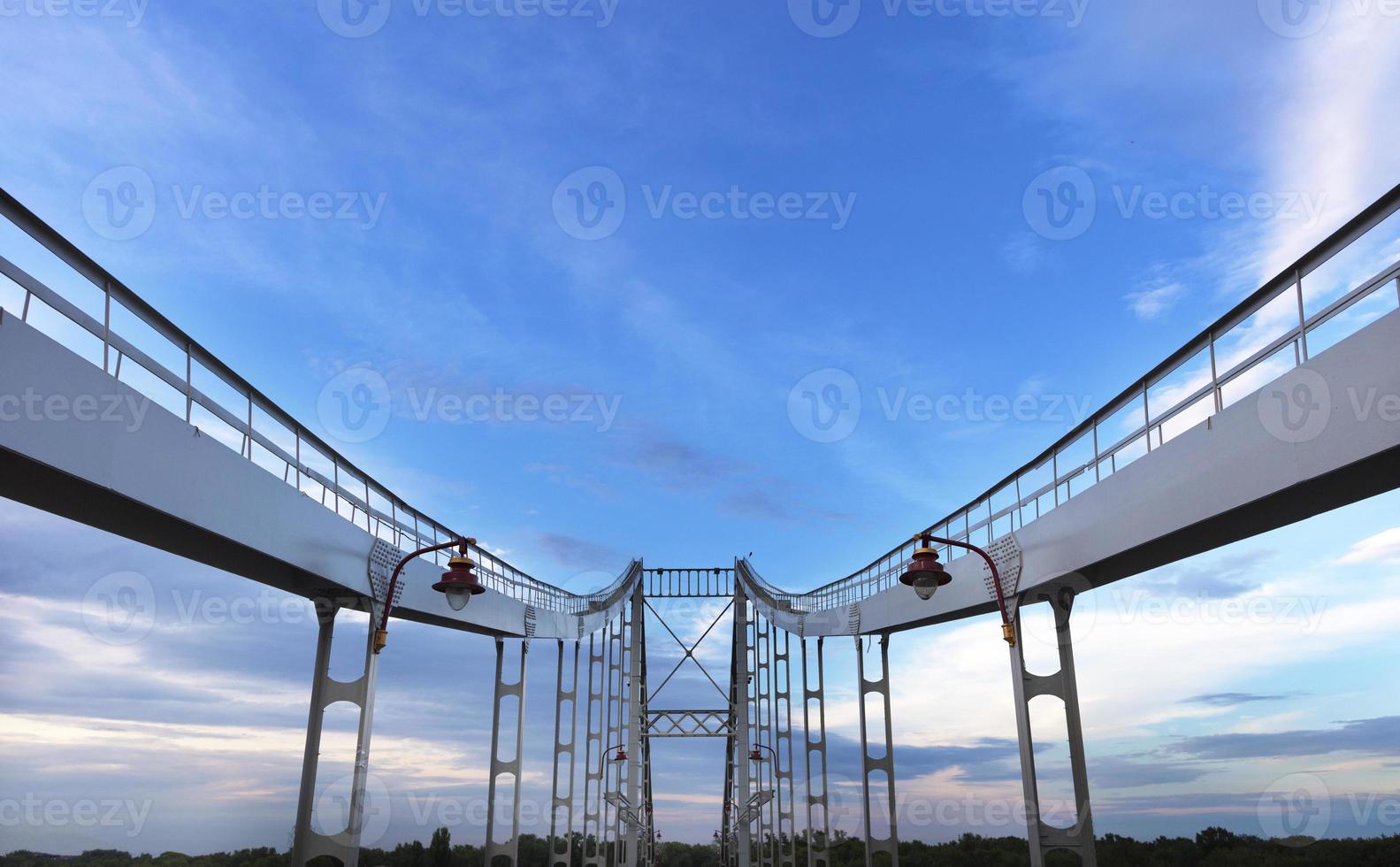 Symmetrical arches of the bridge are directed to the sky photo