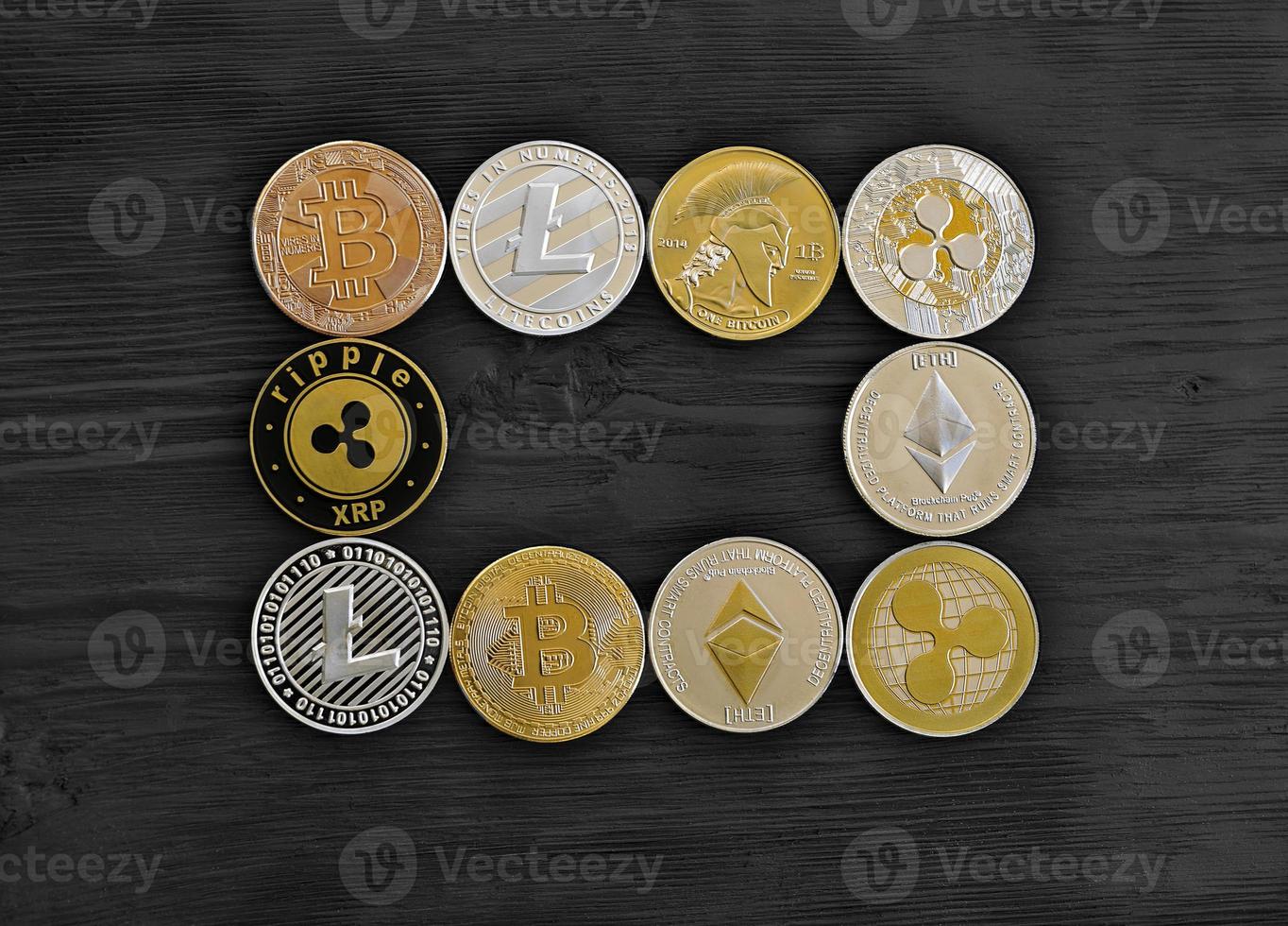 Monedas crypto curency se encuentran sobre una tabla de madera negra foto