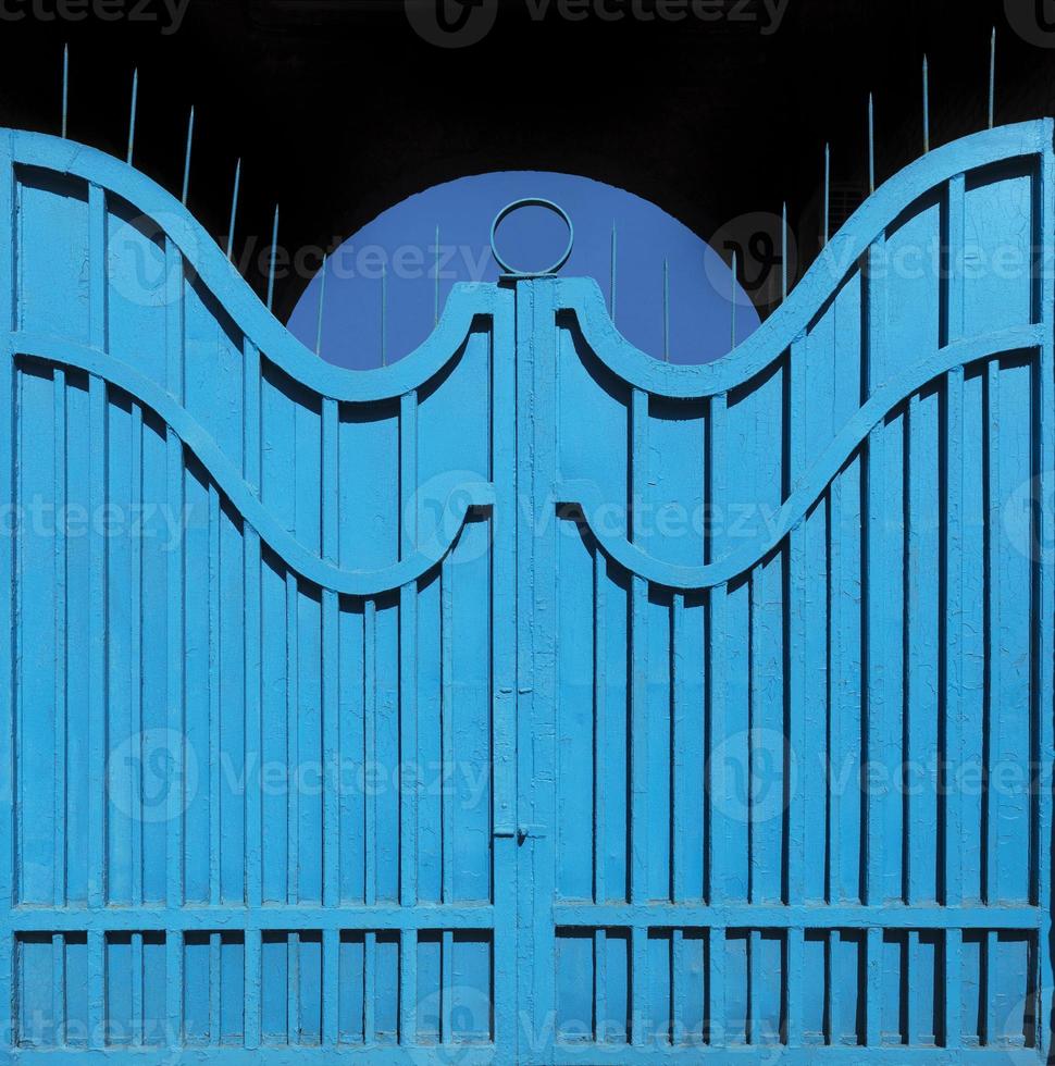 Exemplary metal gate-fence with outdated bright blue paint. Abstract texture background. photo