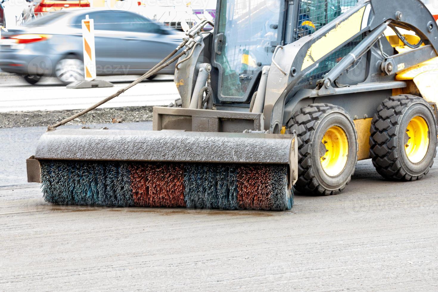 The nylon hydraulic grader brush cleans the roadway from dirt. photo