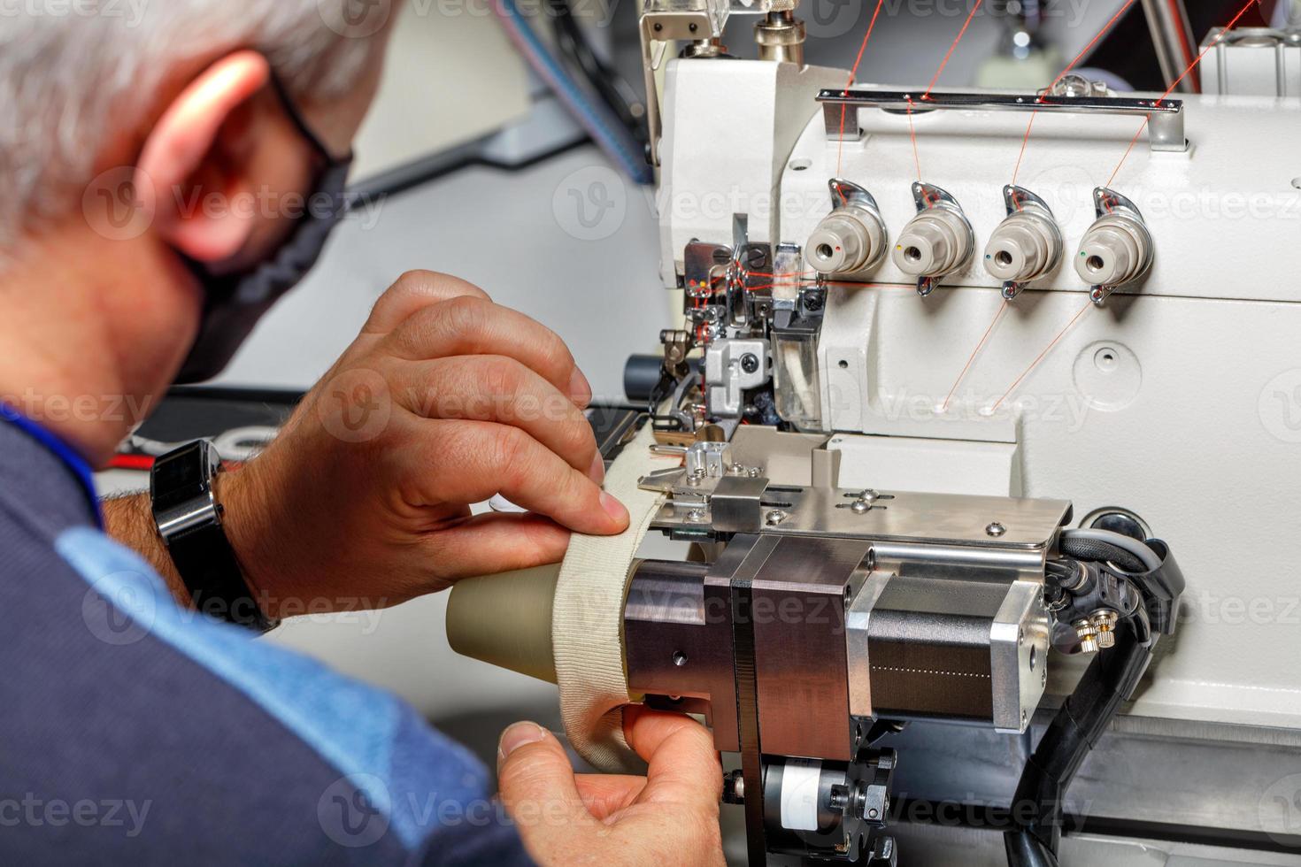 el capataz ajusta el correcto funcionamiento de una máquina de coser moderna. foto